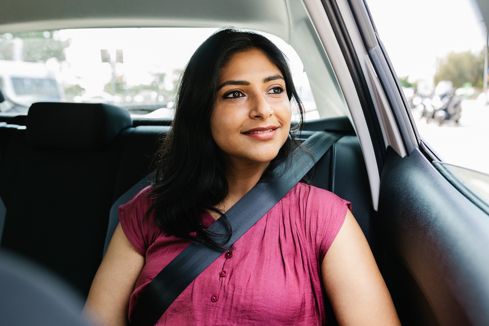 Happy young adult indian woman traveling by car